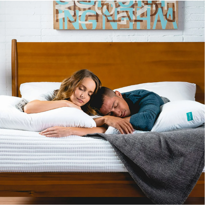 Couple sleeping comfortably on a white Ushaped body pillow promoting restful sleep