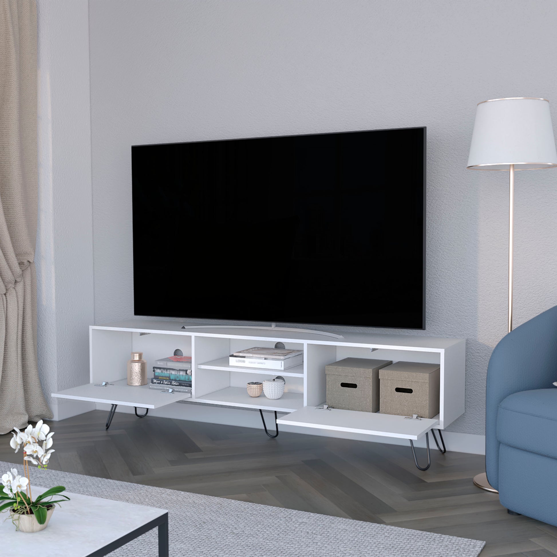 Modern white media console with angled legs and open shelving holding books and decor