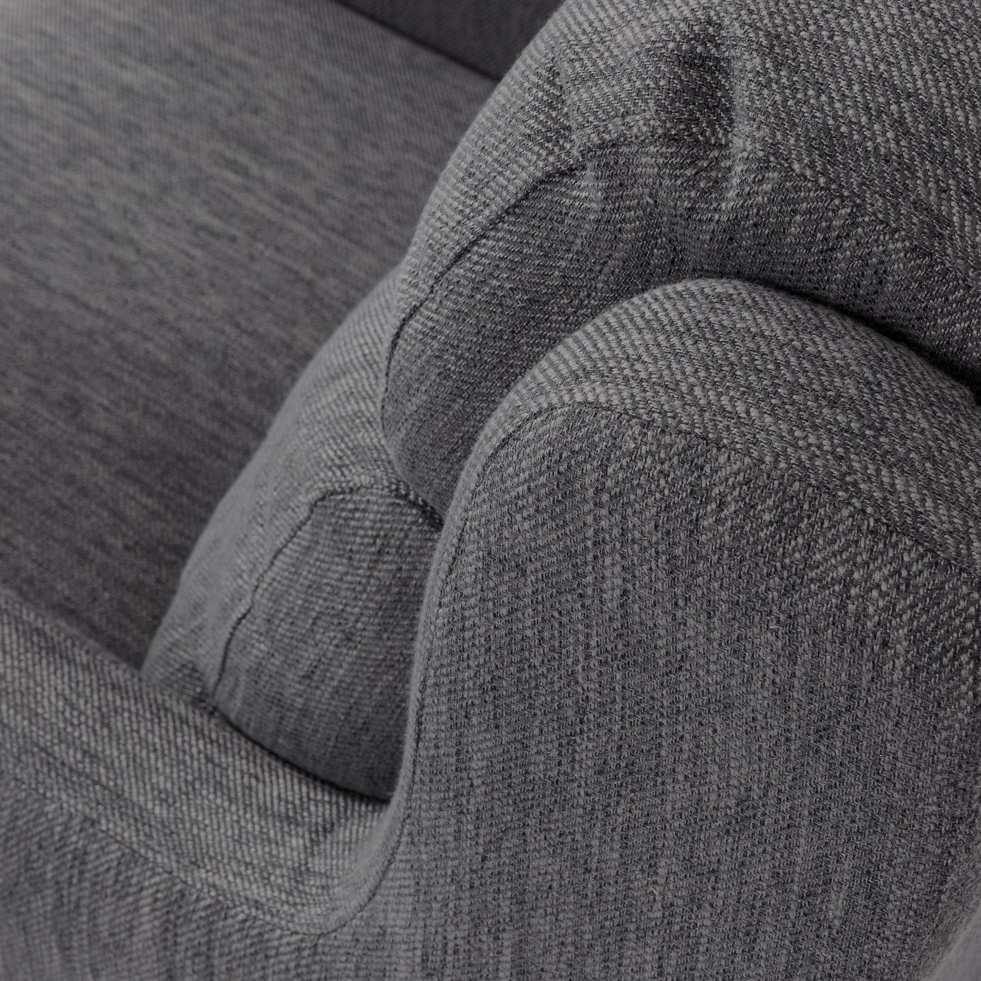 Closeup of a textured charcoal gray woven fabric armchair detail