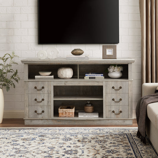 Gray wood TV stand with multiple shelves and drawers holding decor and books