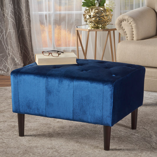 Deep blue velvet rectangular ottoman with button tufting and dark wood legs a chic accent piece