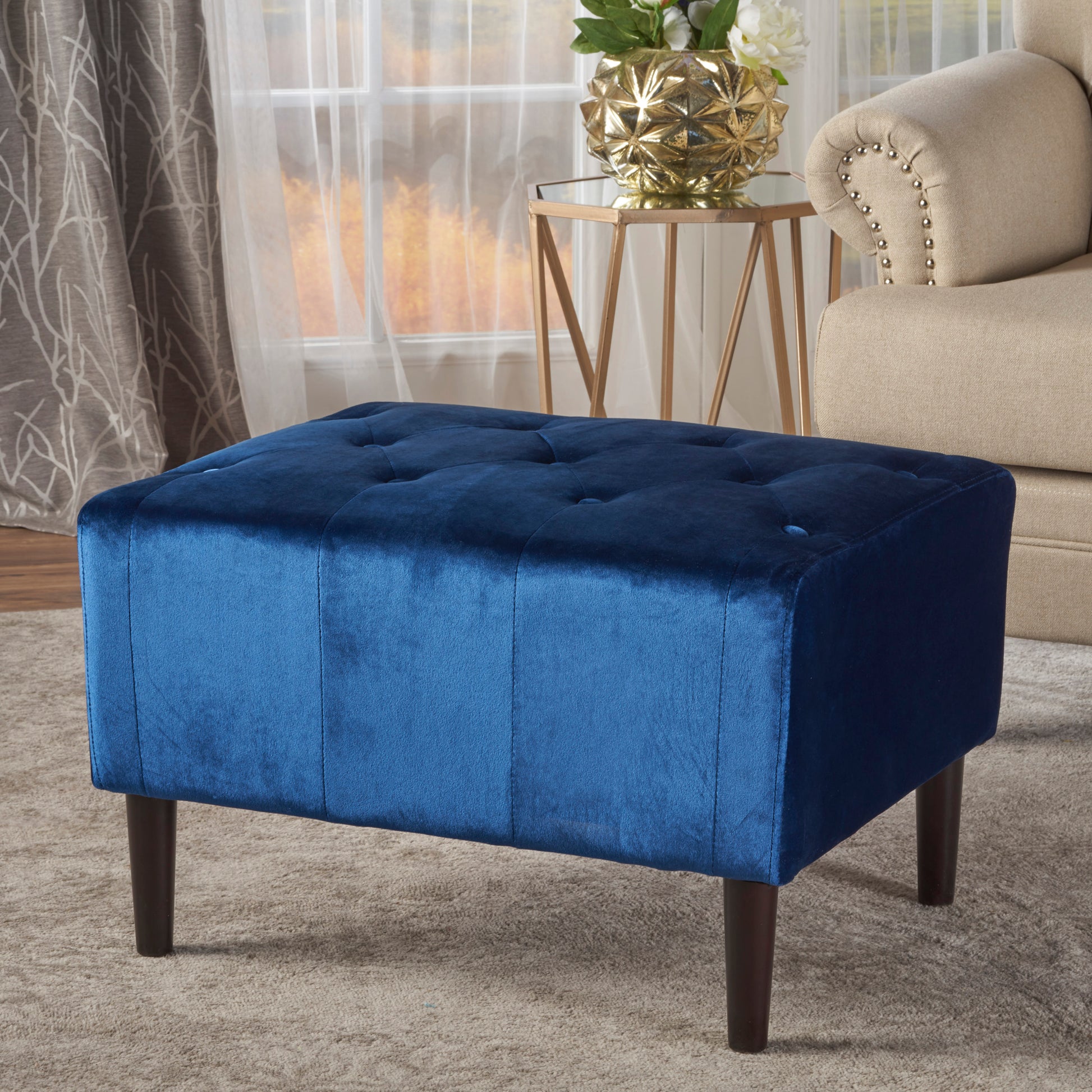 Tufted navy velvet ottoman with dark wood legs perfect accent for living rooms