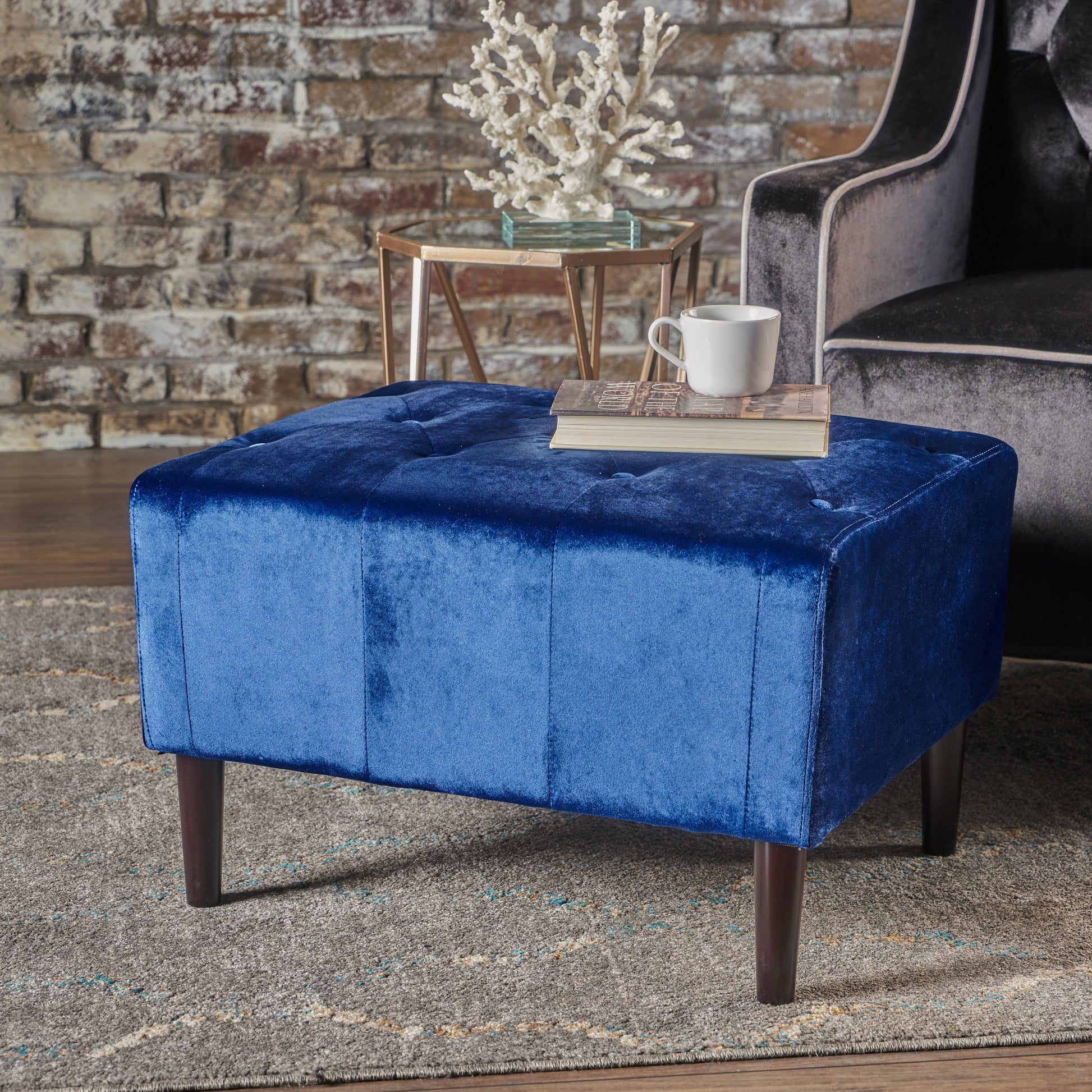 Deep blue velvet tufted ottoman with dark wood legs and button detail