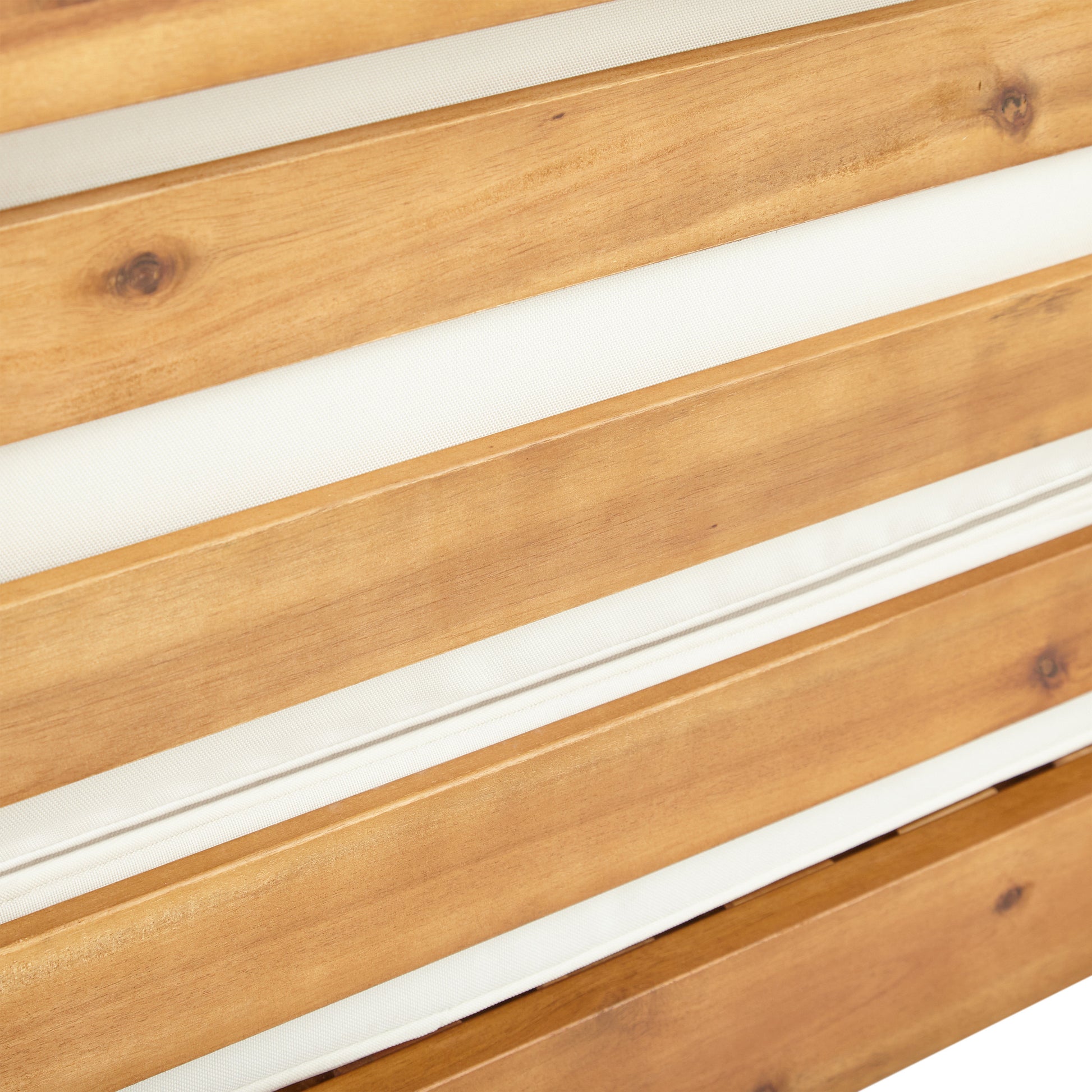 Closeup of natural acacia wood slats with white cushion detail ideal for outdoor furniture