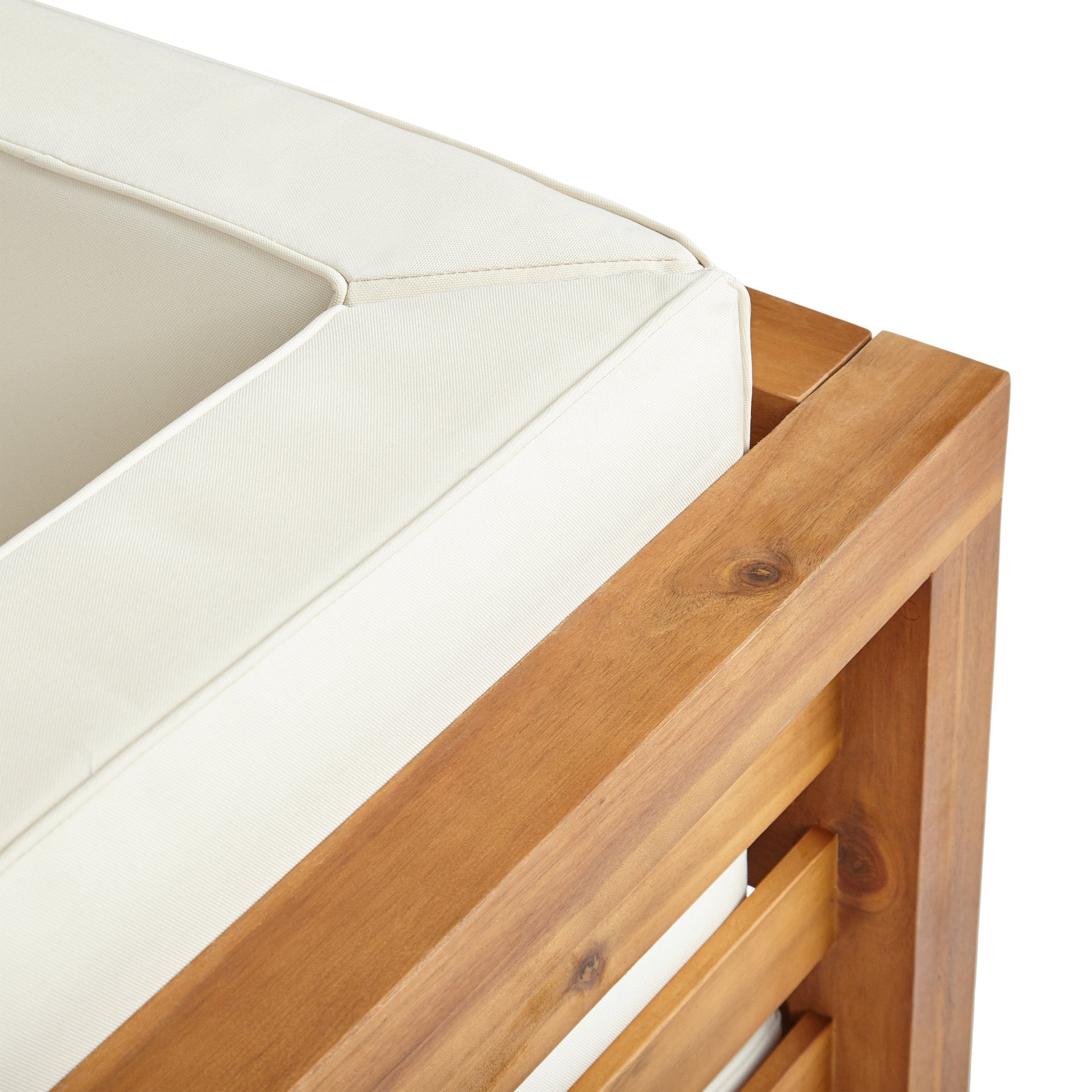 Closeup of plush cream outdoor patio cushion on a warmtoned wooden frame