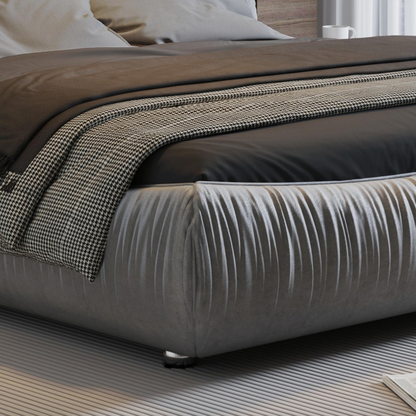 Plush grey tufted bed frame with dark brown linens and a houndstooth throw