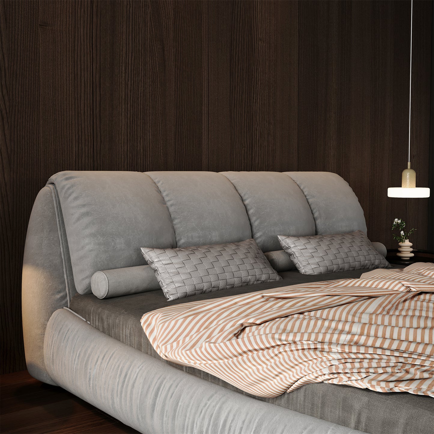 Gray upholstered bed with tufted headboard and striped duvet