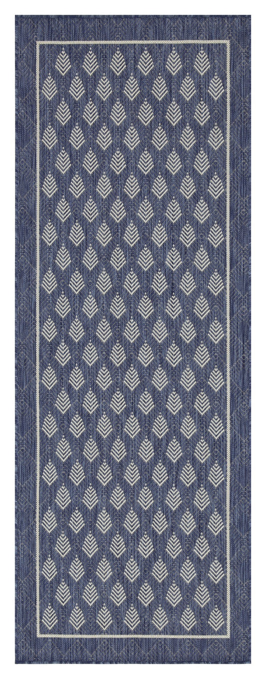 Navy blue outdoor rug with a repeating white geometric diamond pattern and a white border