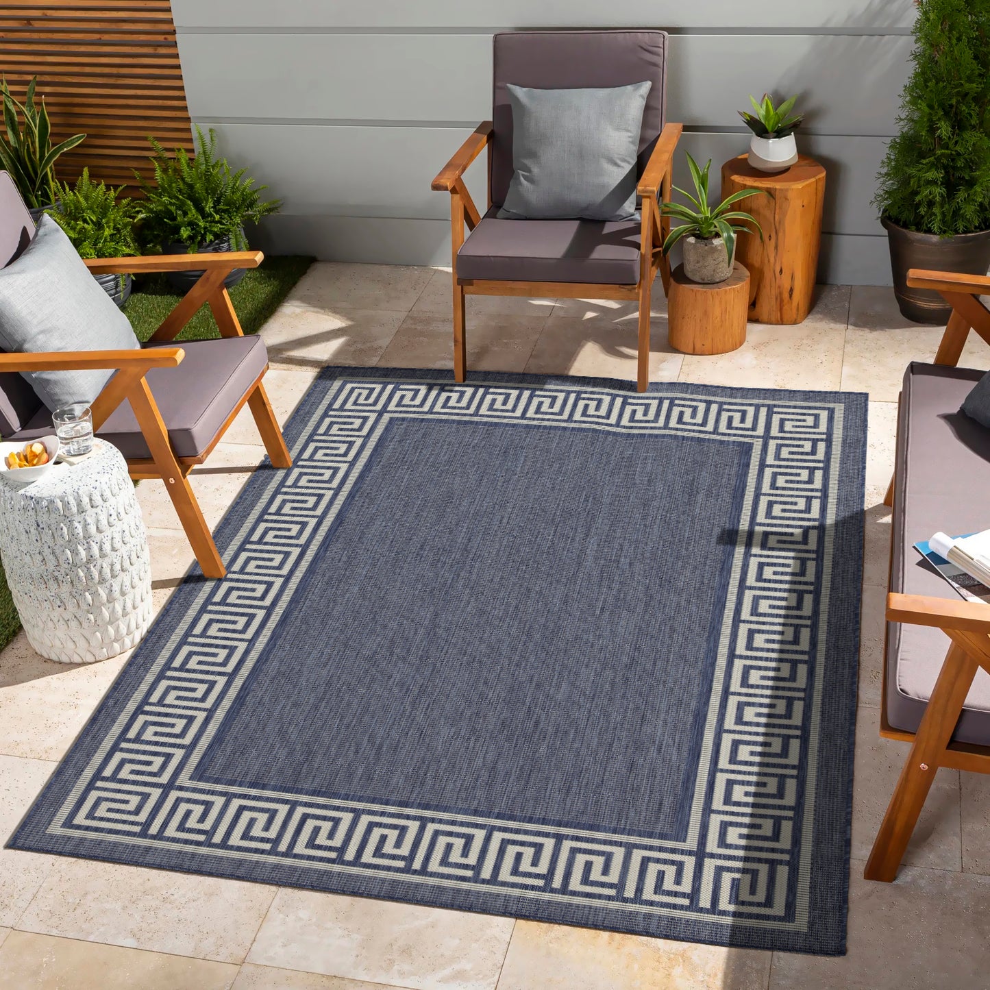 Navy blue area rug with a Greek key border perfect for outdoor patios