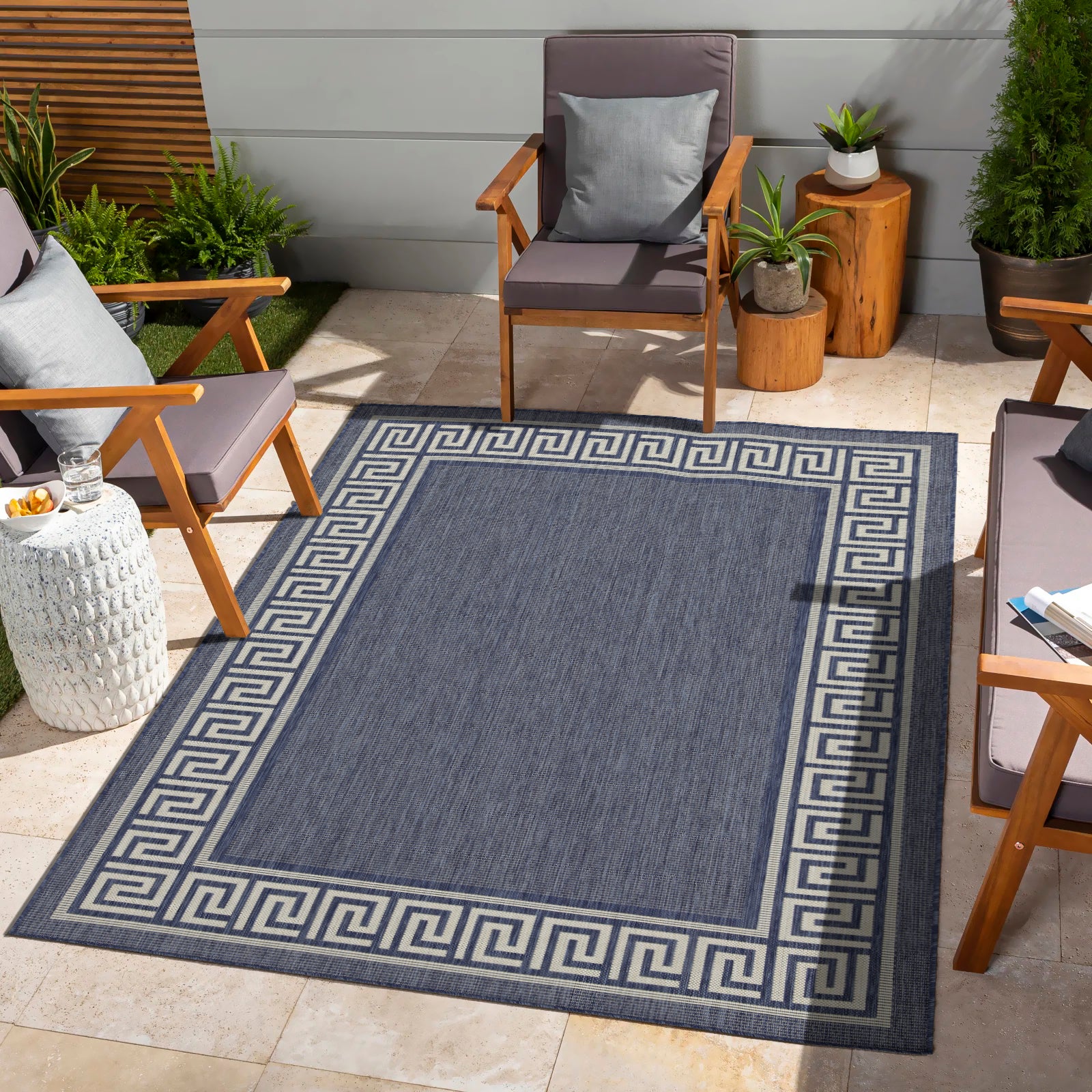 Navy blue area rug with a Greek key border perfect for outdoor patios