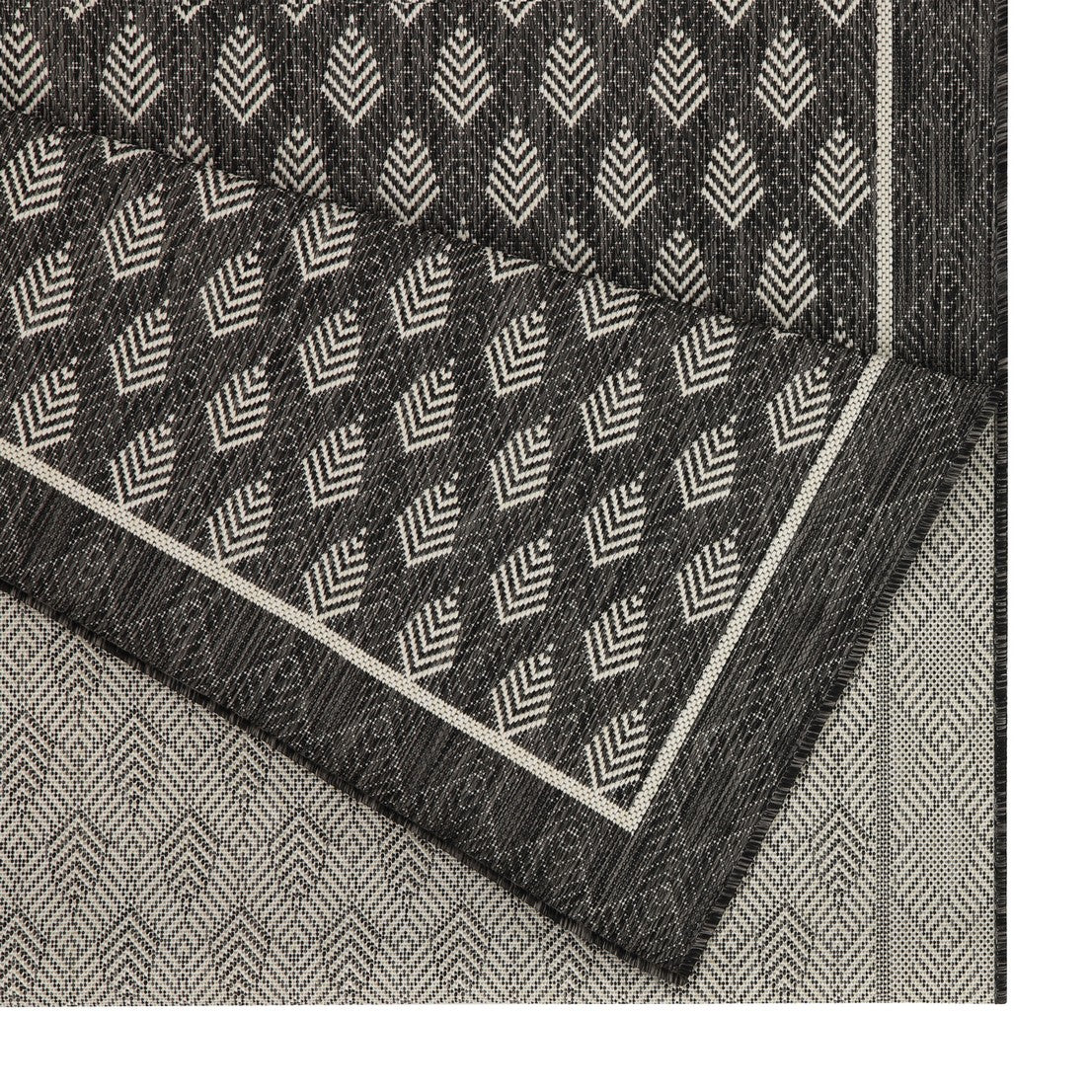 Dark gray outdoor rug with a white geometric diamond pattern and contrasting border