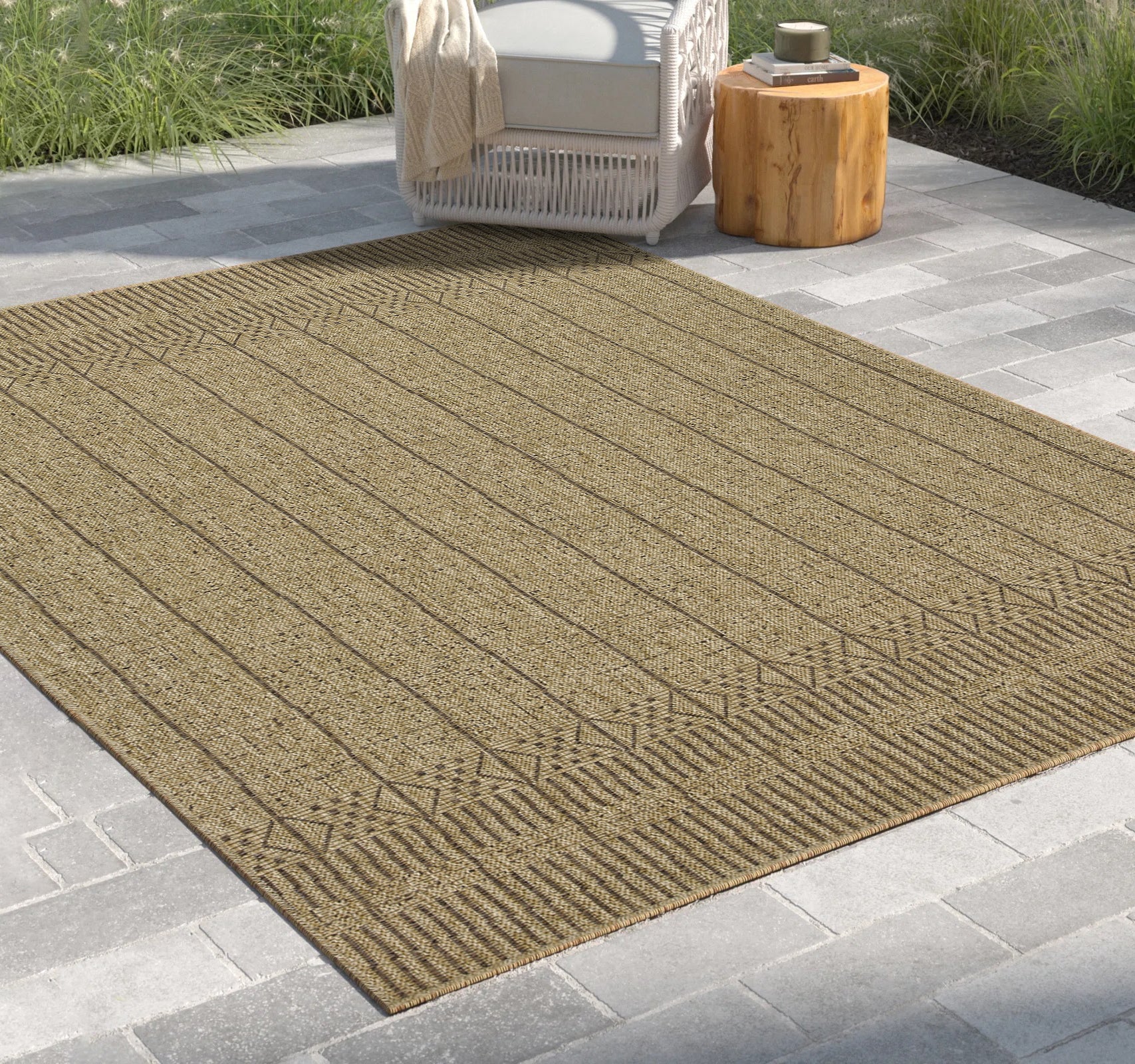 Woven tan outdoor rug with subtle geometric border and striped pattern