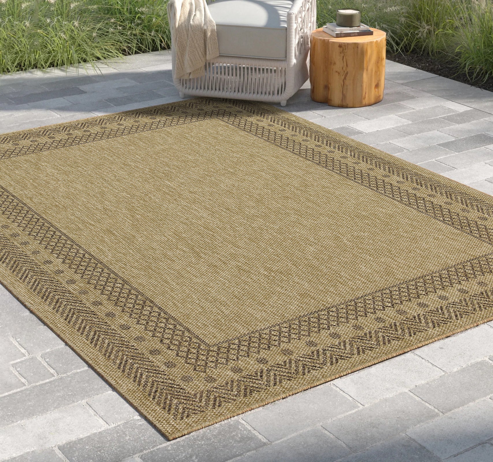 Flat weave outdoor rug in tan with a geometric brown border perfect for patios