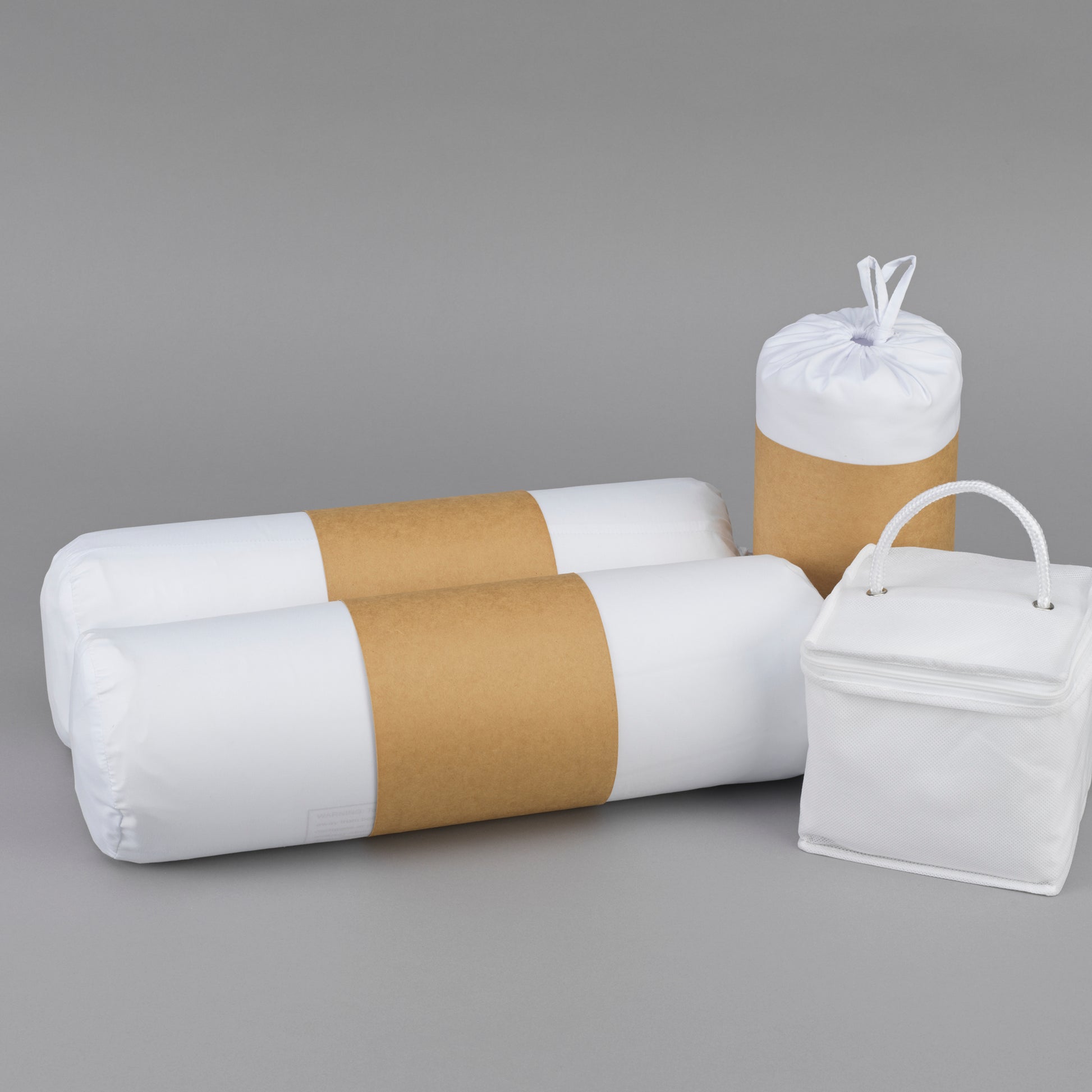 Two white bolster pillows in plastic packaging with brown bands