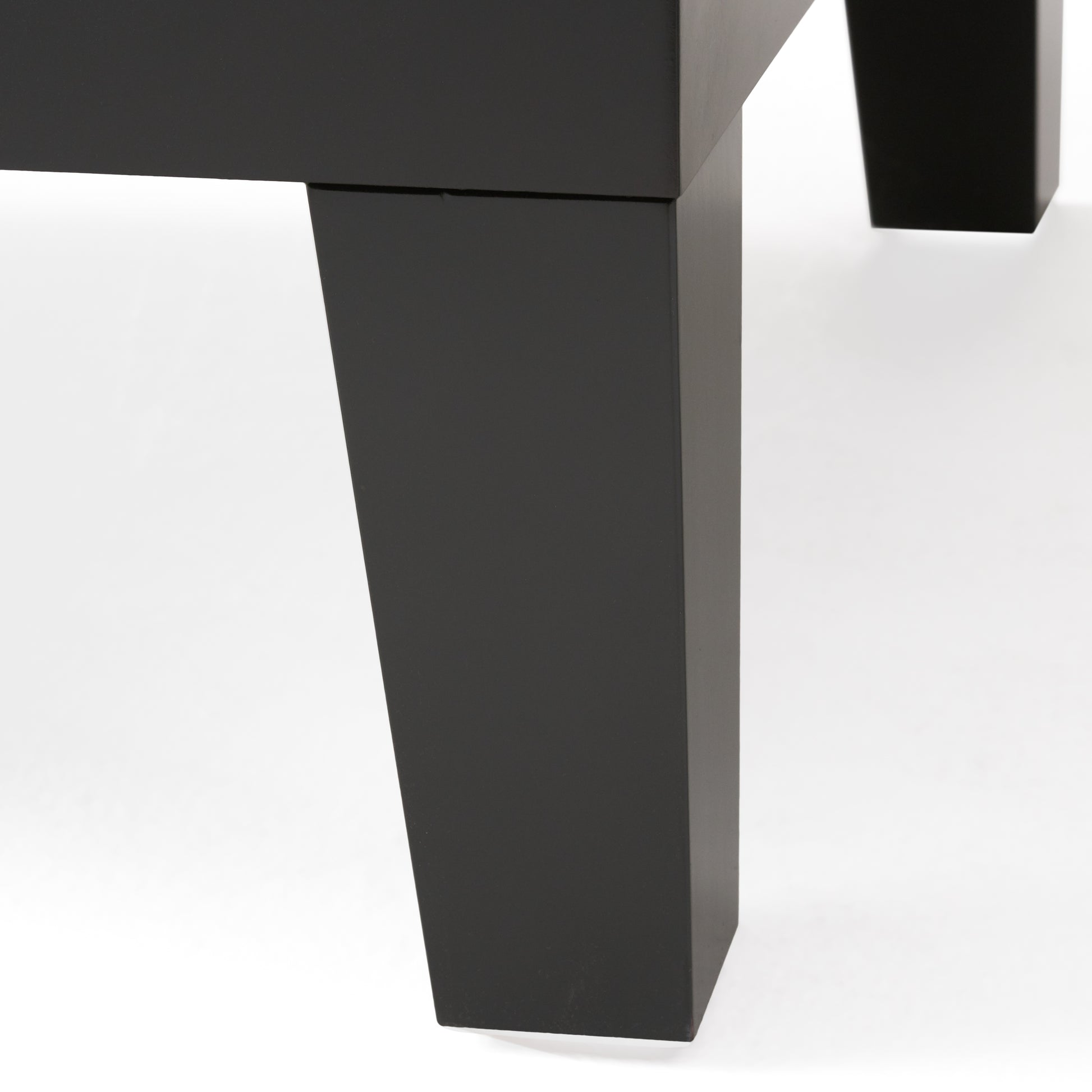 Closeup of a modern black metal table leg showcasing its sleek geometric design