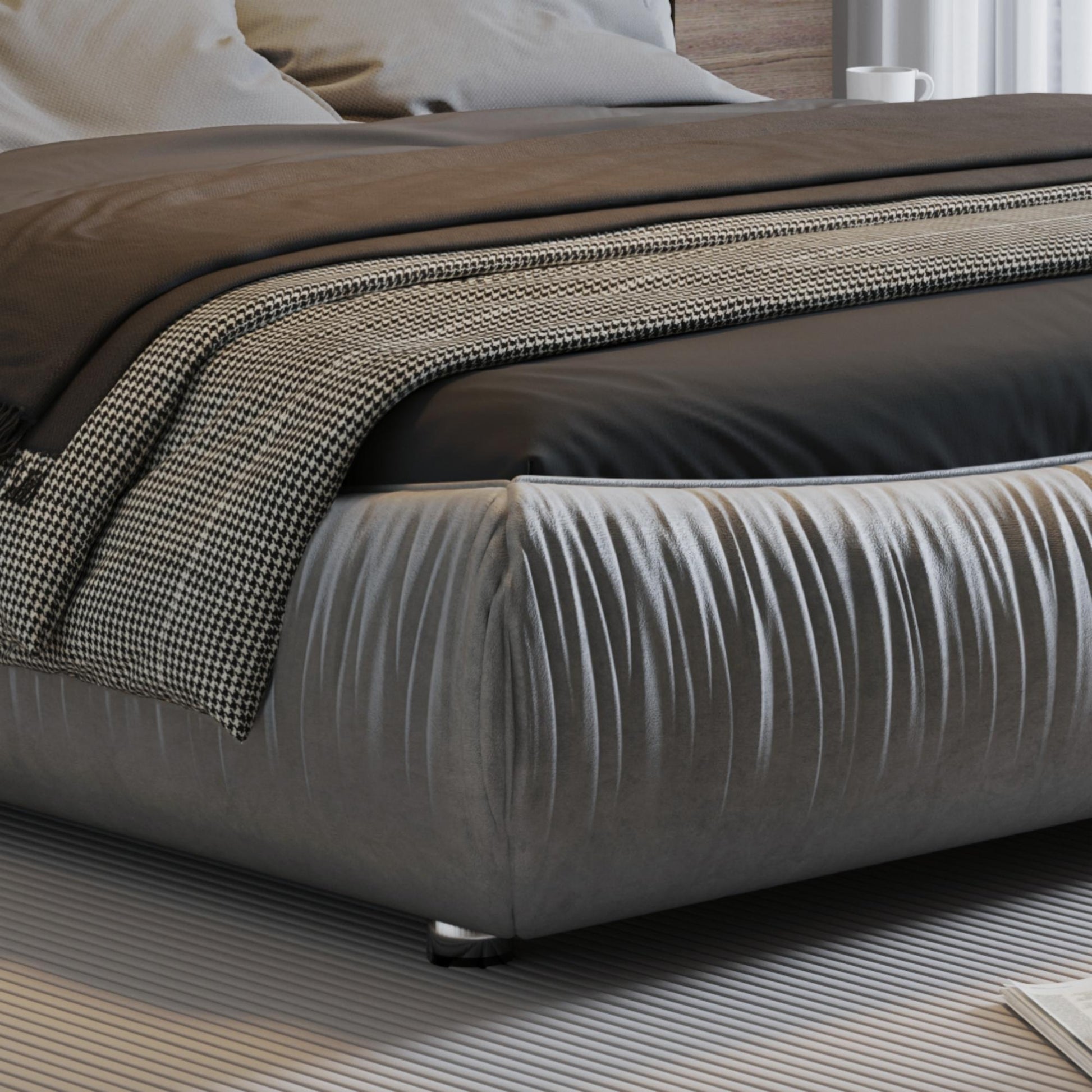 Tufted grey bed frame with plush upholstery and a houndstooth throw blanket