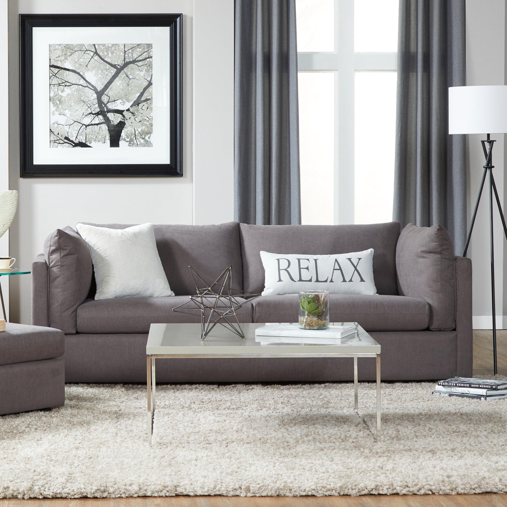 Dark gray fabric sofa with white textured pillow and RELAX lumbar pillow
