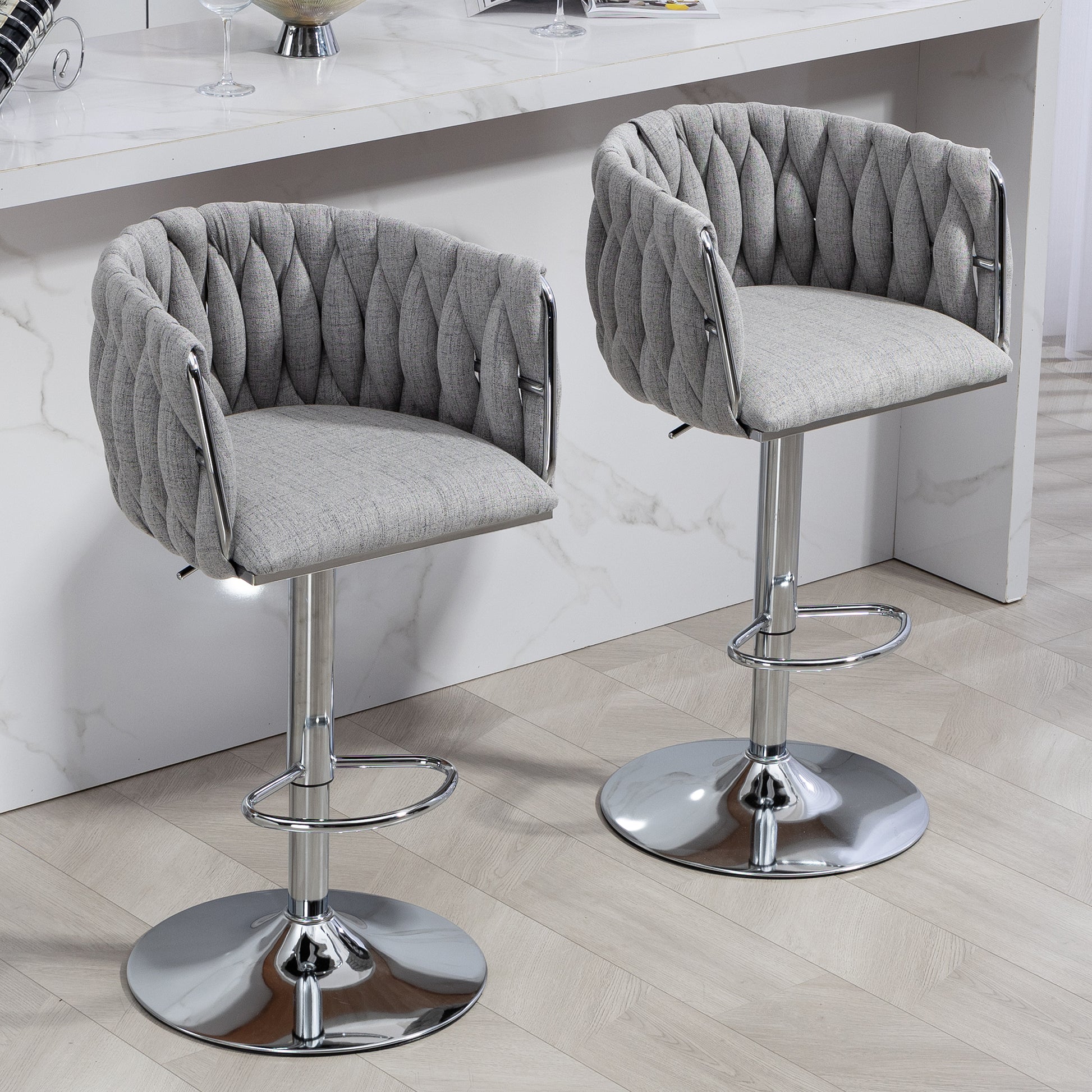 Grey upholstered bar stool with chrome base and armrests