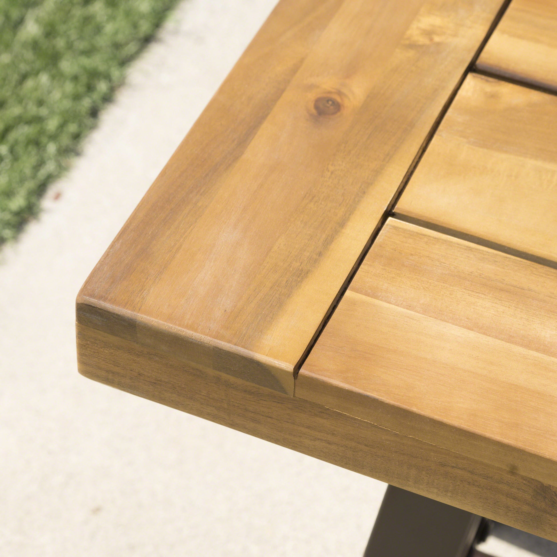 Closeup of a warmtoned wooden outdoor dining table surface with natural grain