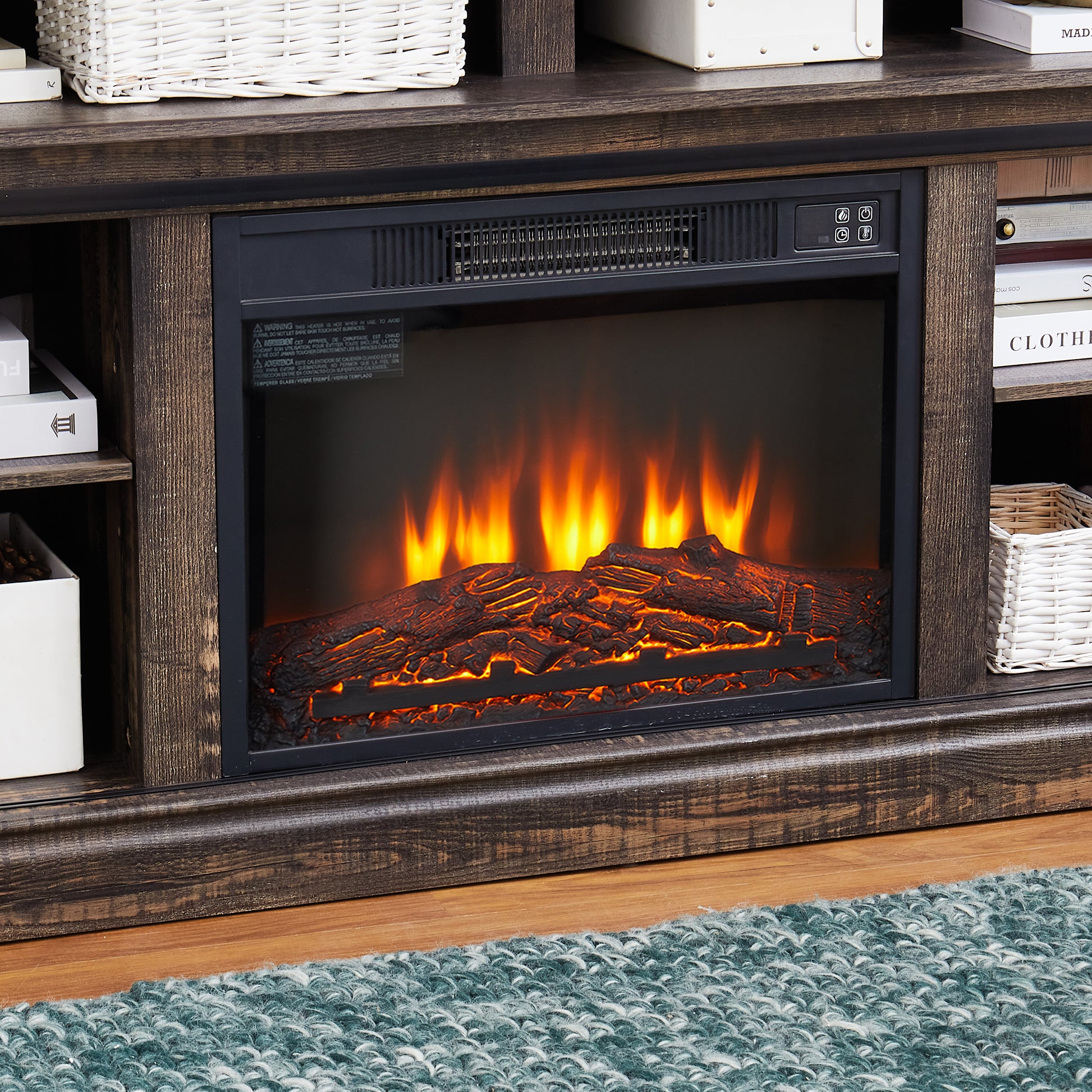 Realistic electric fireplace logs glowing with orange flames part of a rustic entertainment center