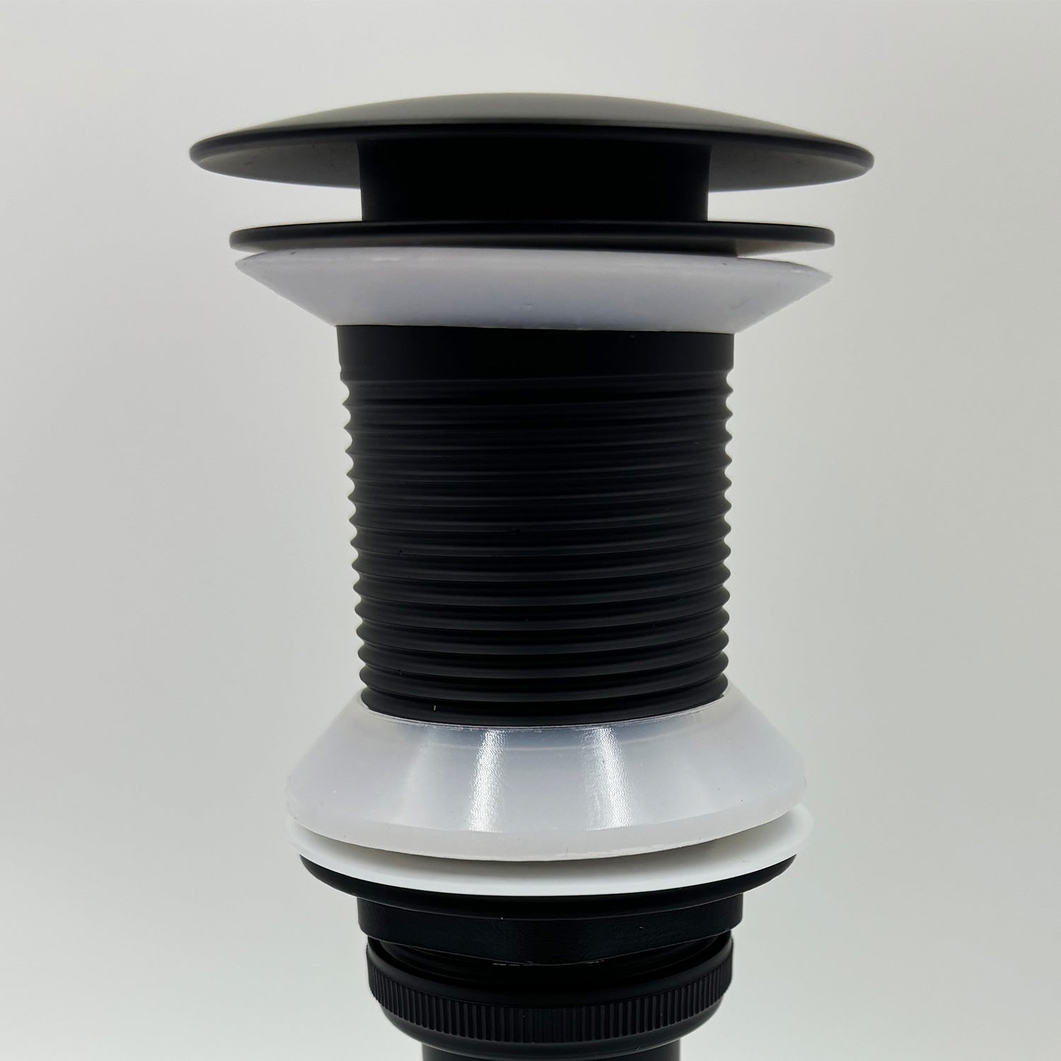 Black and white popup drain assembly with ribbed stem for bathroom sink
