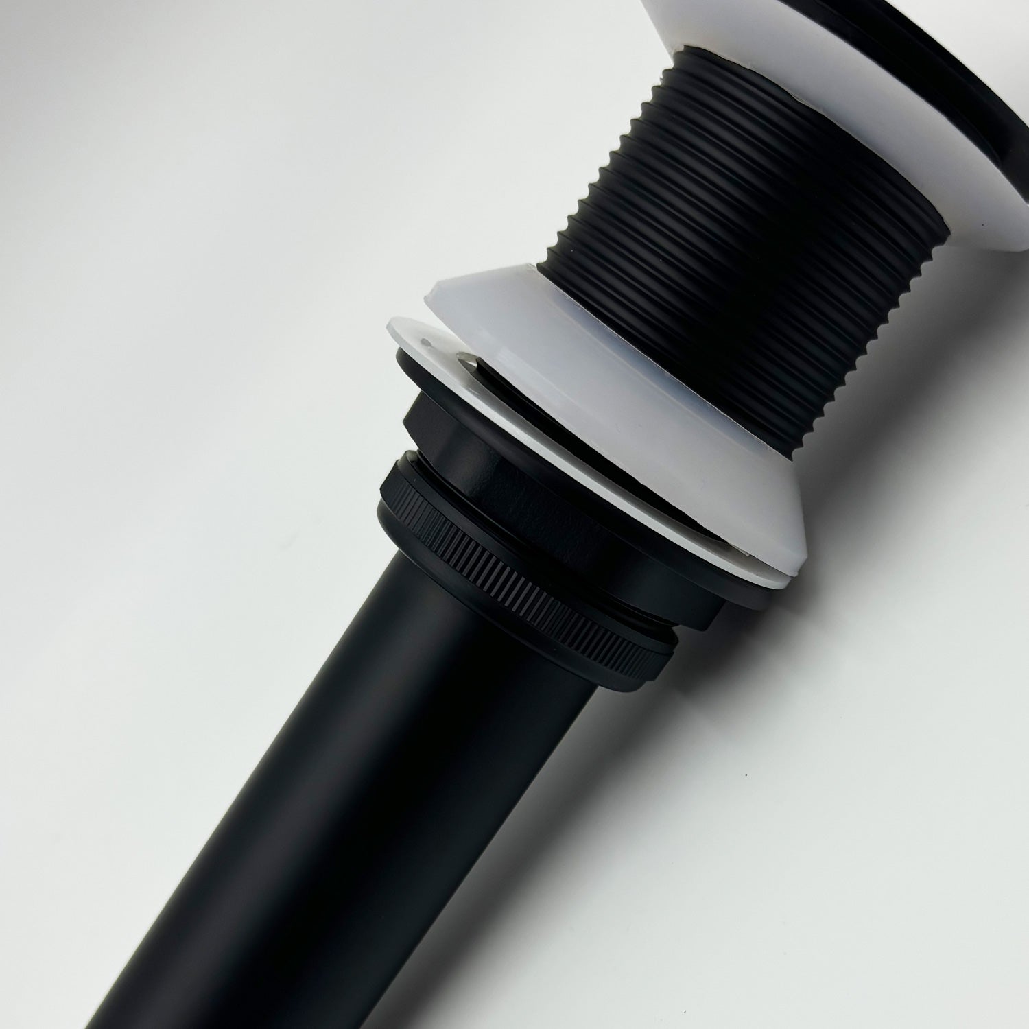 Matte black sink drain assembly with corrugated flexible pipe and white gaskets