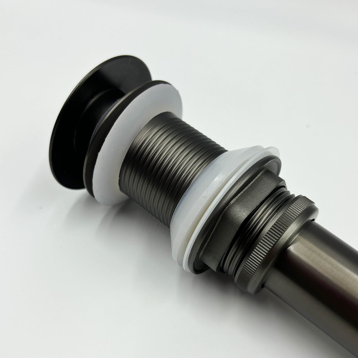 Black finished brass drain assembly with ribbed body and white seal