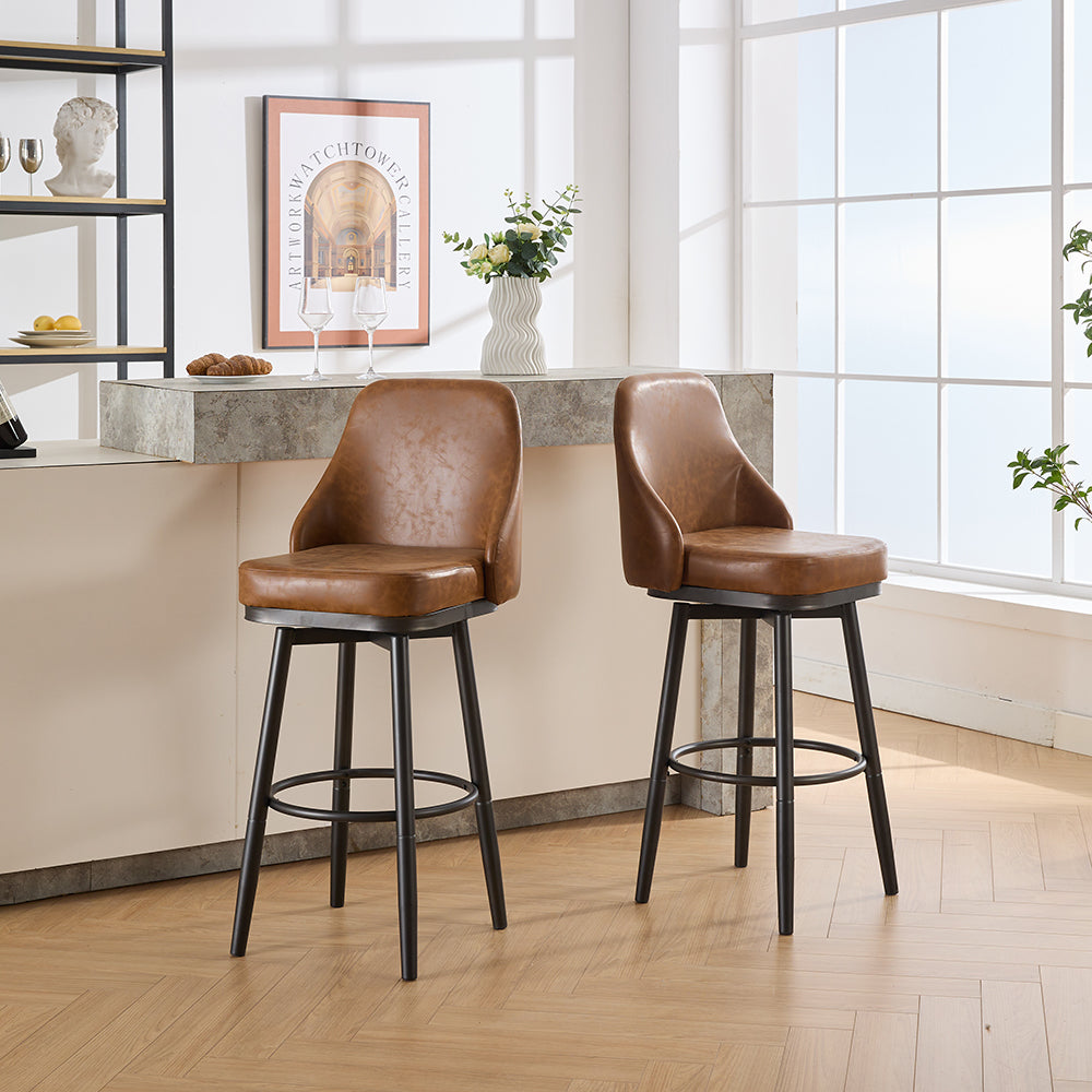 Two distressed brown leather bar stools with black metal legs are positioned by a kitchen counter