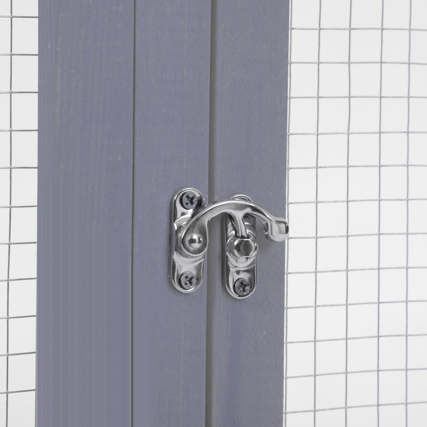 Closeup of a grey wooden pet enclosure with a silver metal latch and wire mesh