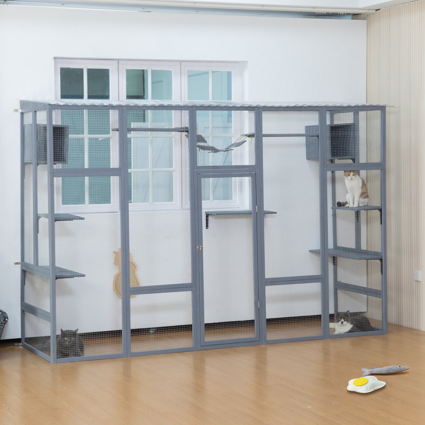 Spacious gray outdoor catio with multiple levels perches and two cats enjoying playtime