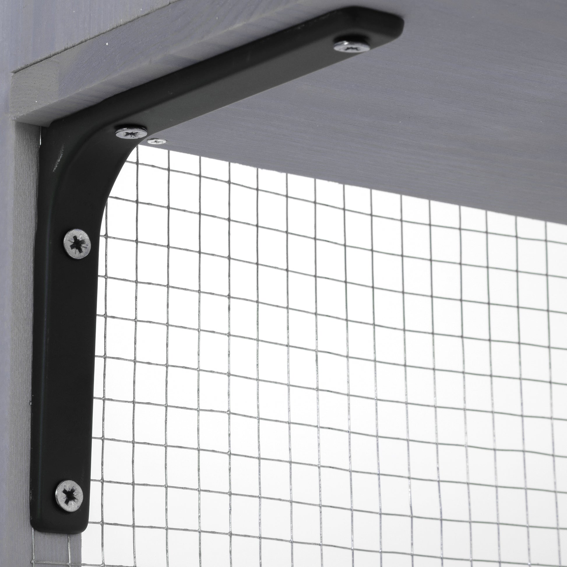 Black metal shelf bracket screwed into a grey wooden shelf and post