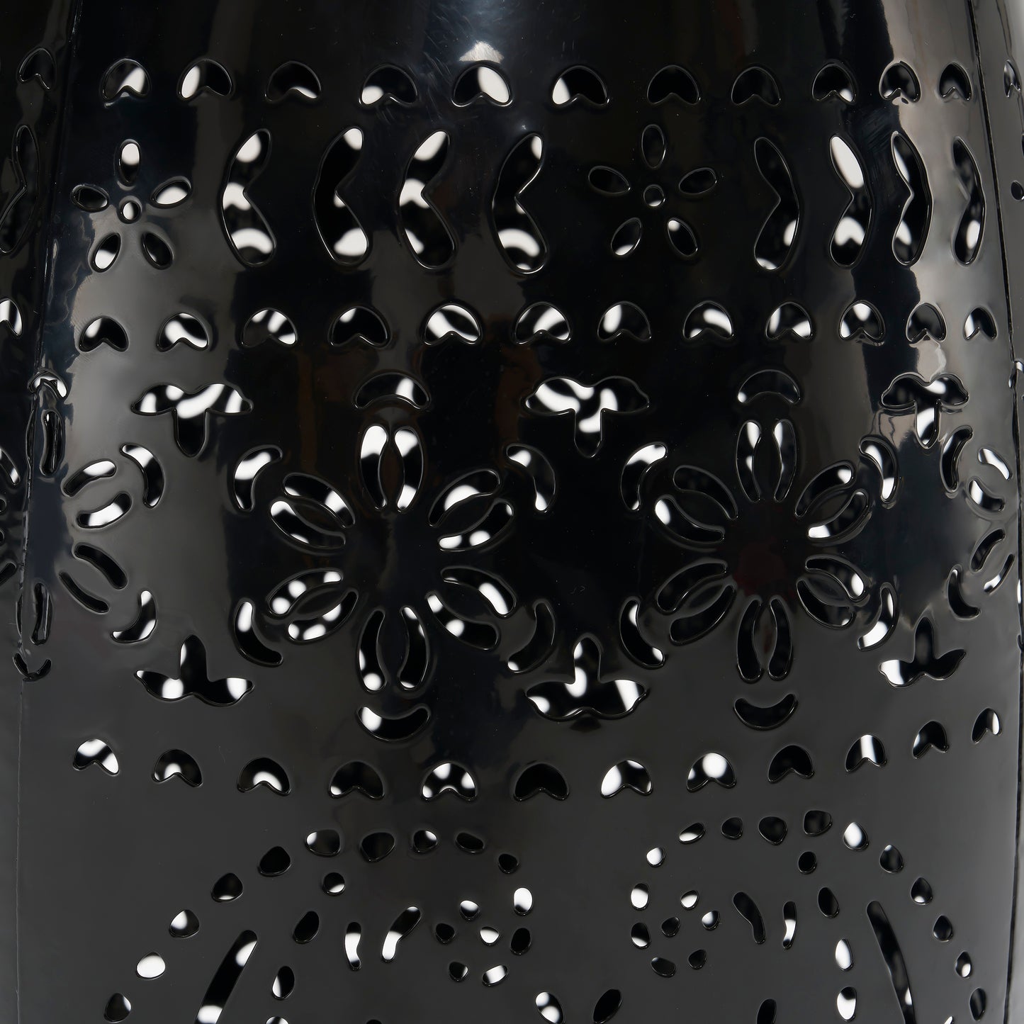 Black metal lantern with intricate floral cutouts perfect for outdoor ambiance