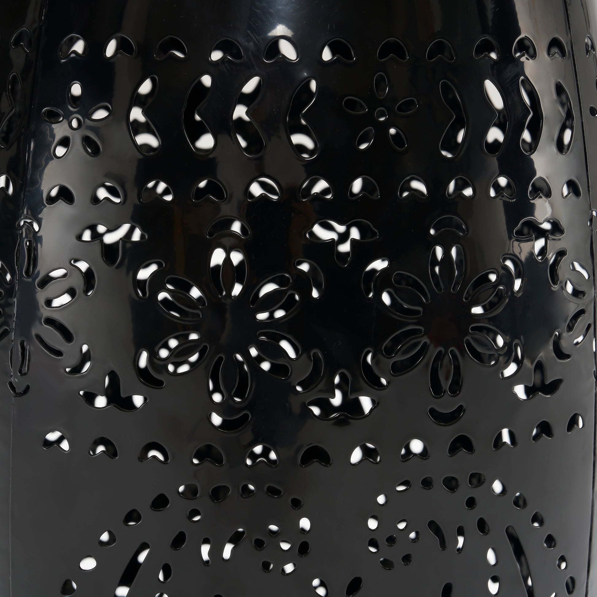 Black metal lantern with intricate floral cutouts perfect for outdoor ambiance