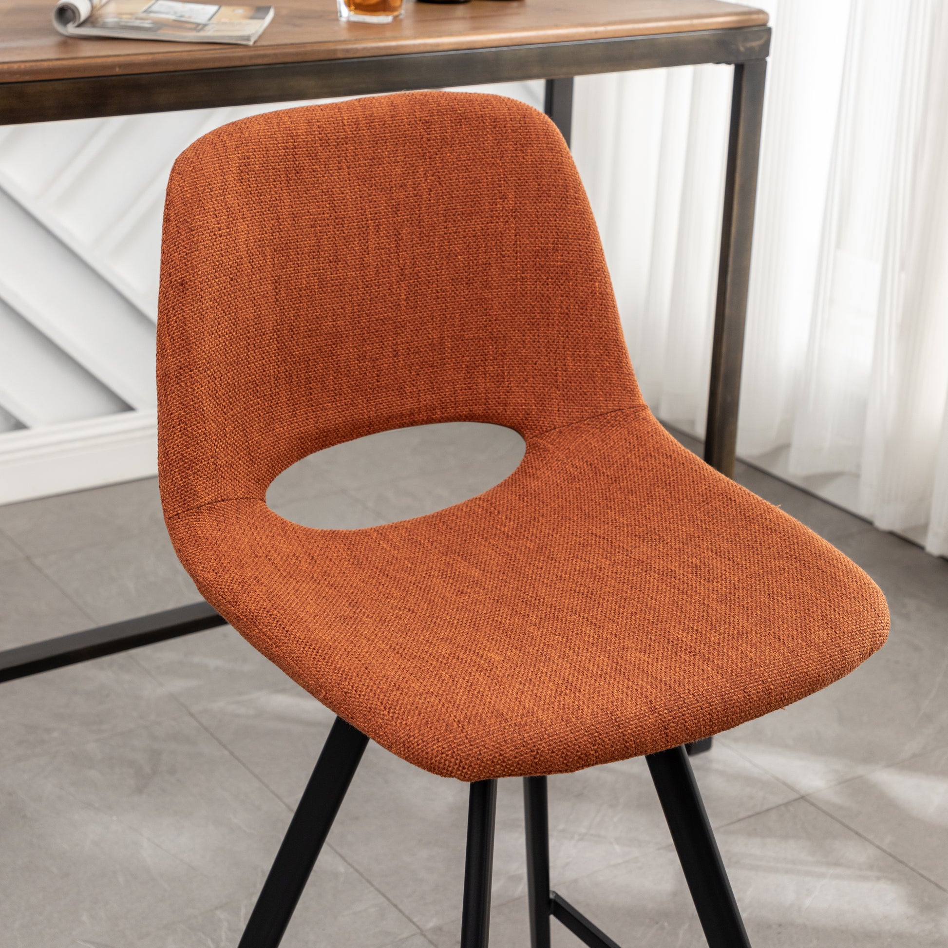 Orange textured fabric dining chair with black metal legs