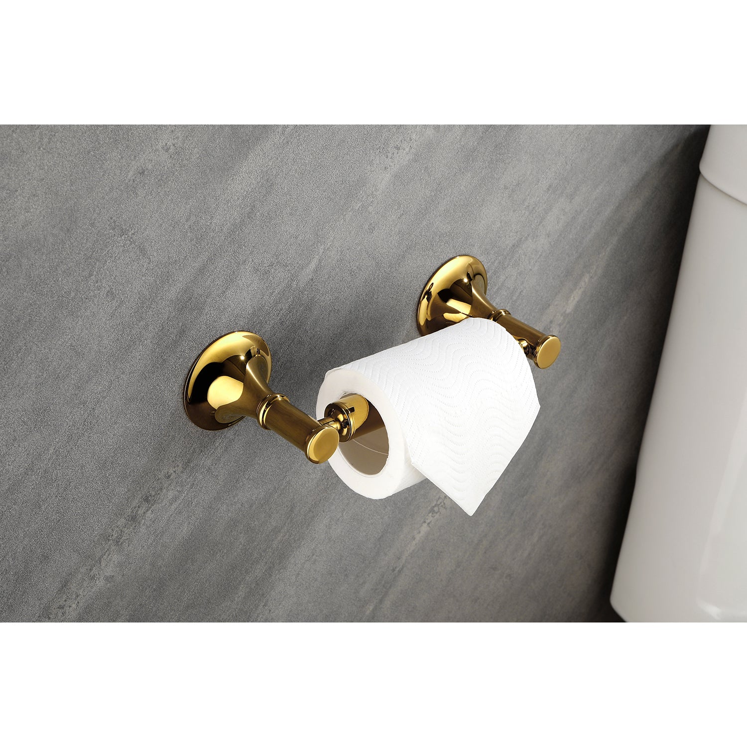 Polished brass toilet paper holder with a white roll mounted on gray textured wall