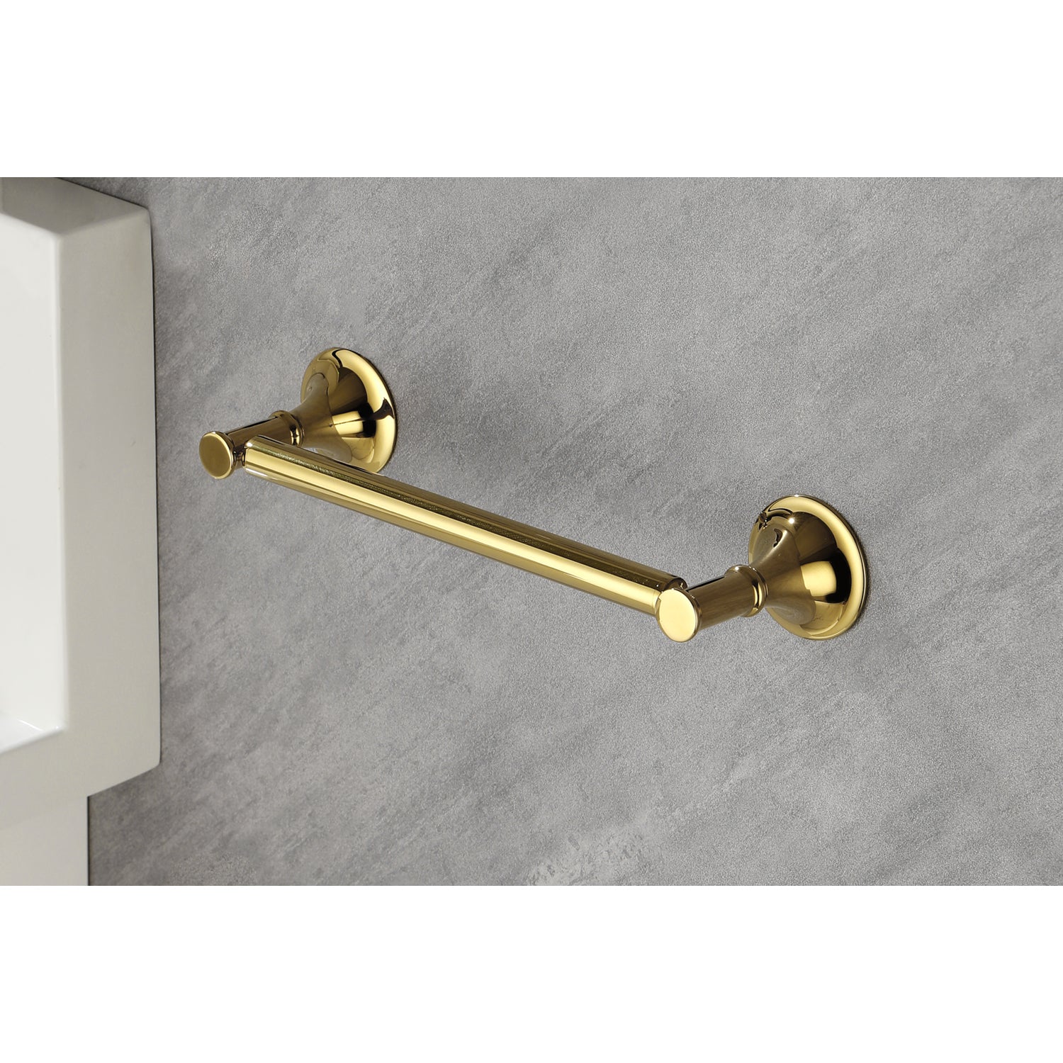 Polished brass single towel bar with decorative end caps mounted on a textured gray wall