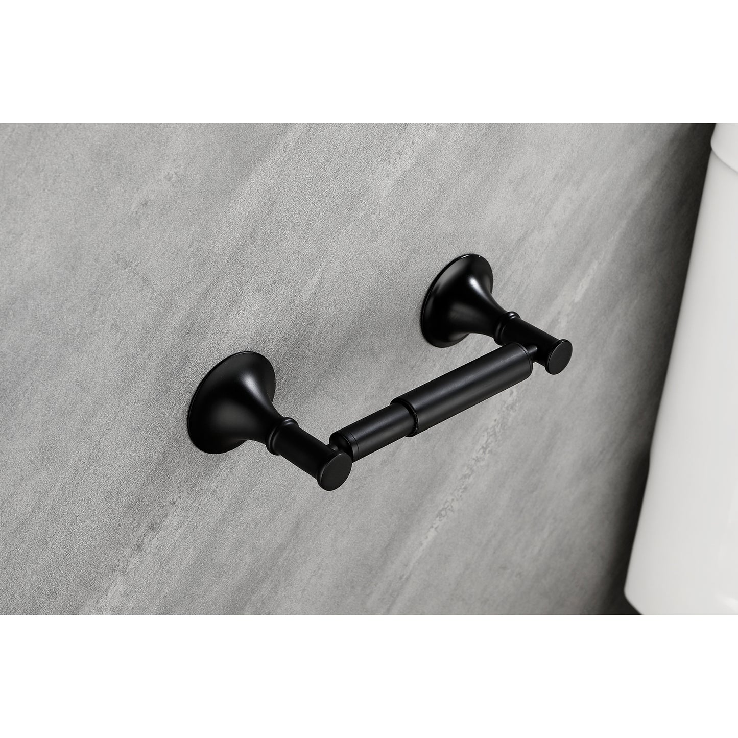 Matte black vintage toilet paper holder with ornate base on textured gray wall