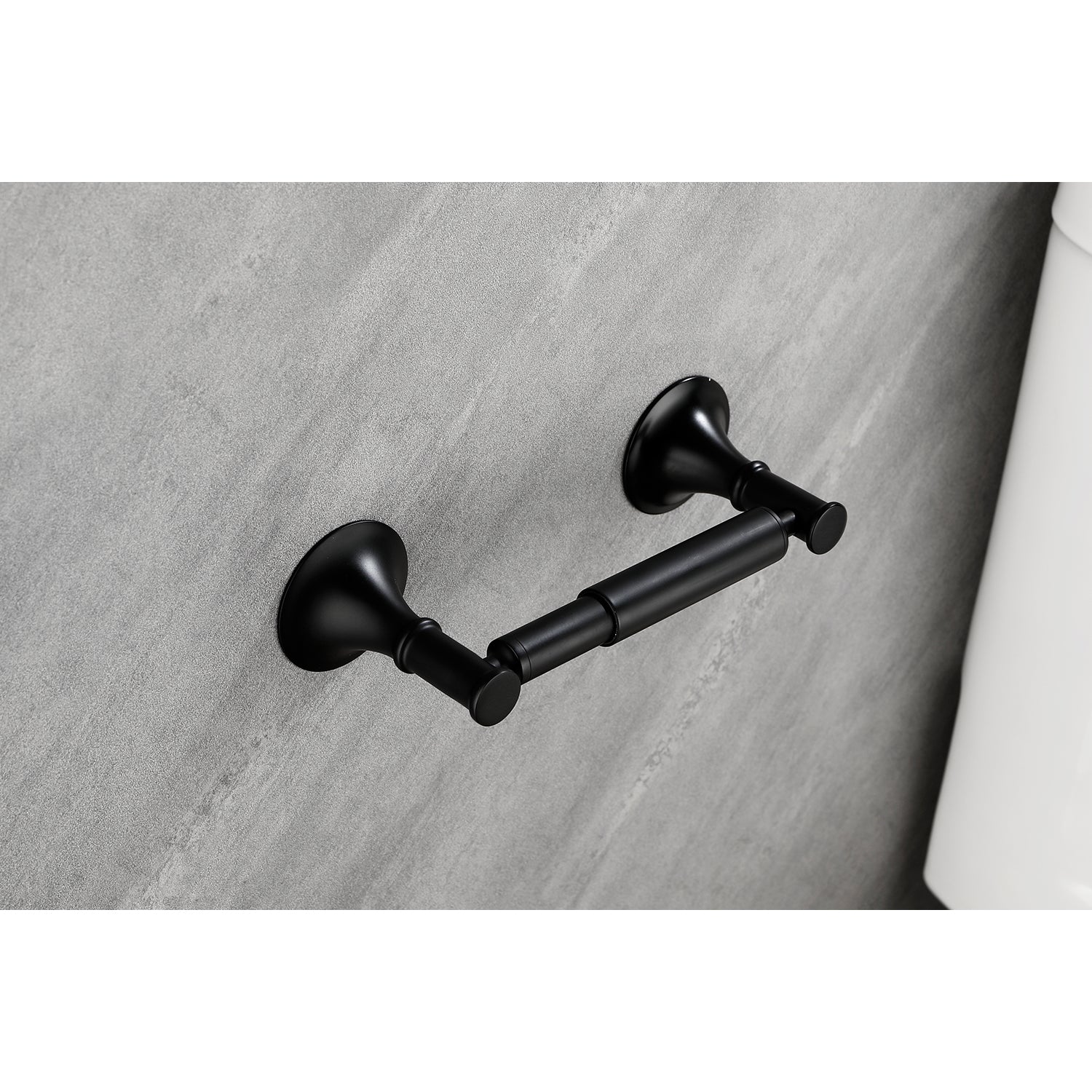 Matte black vintage toilet paper holder with ornate base on textured gray wall