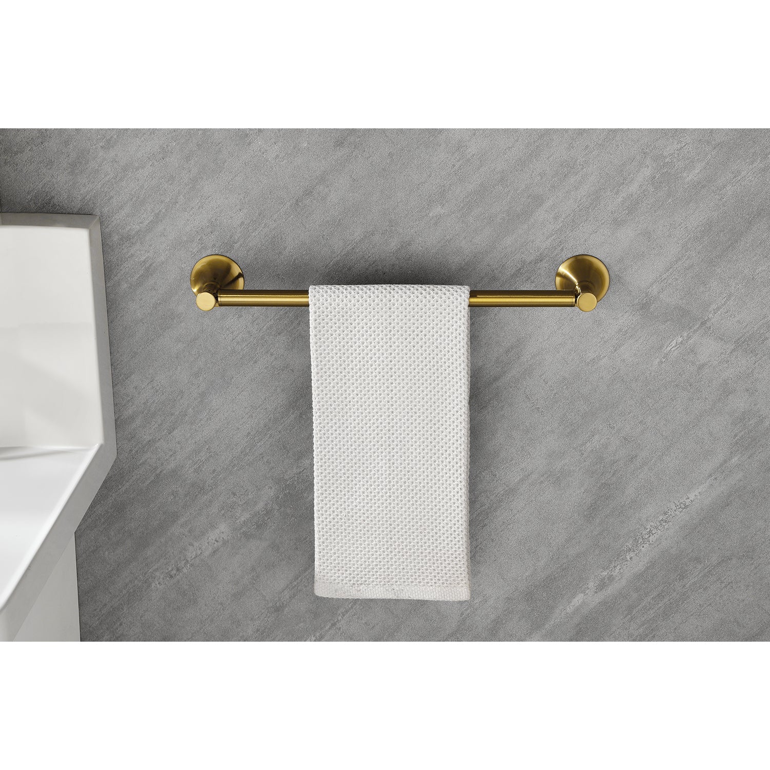 Brushed brass towel bar with a modern design holding a white textured hand towel