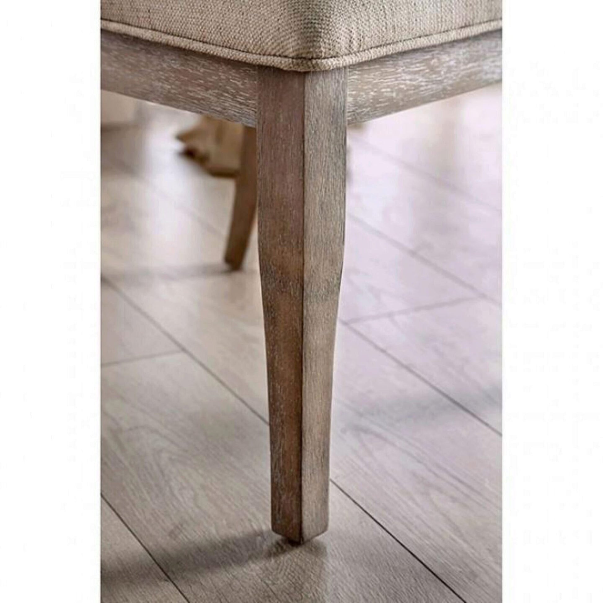 Tapered light oak dining chair leg on a light wood floor