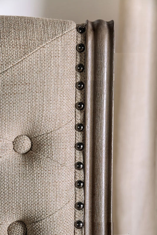 Tufted linen headboard detail with antique brass nailhead trim