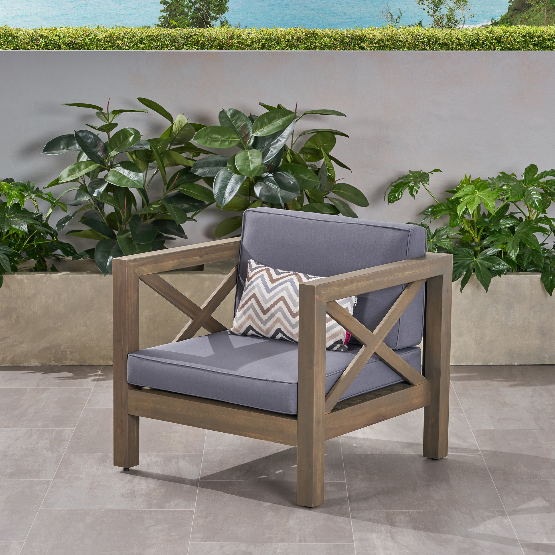 Modern grey outdoor armchair with decorative Xframe and plush cushions