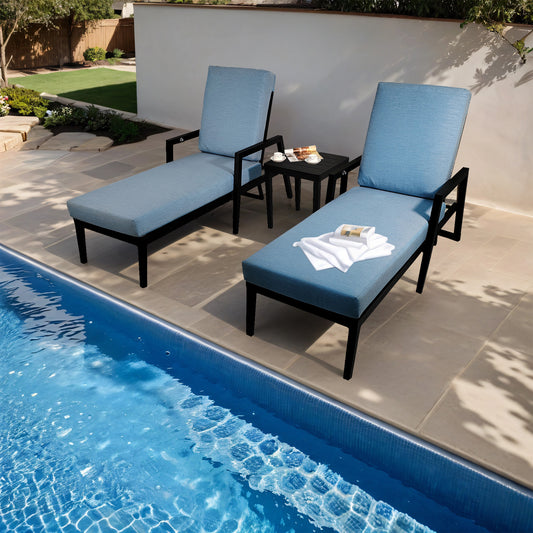 Two light blue cushioned chaise lounge chairs with black frames beside a pool