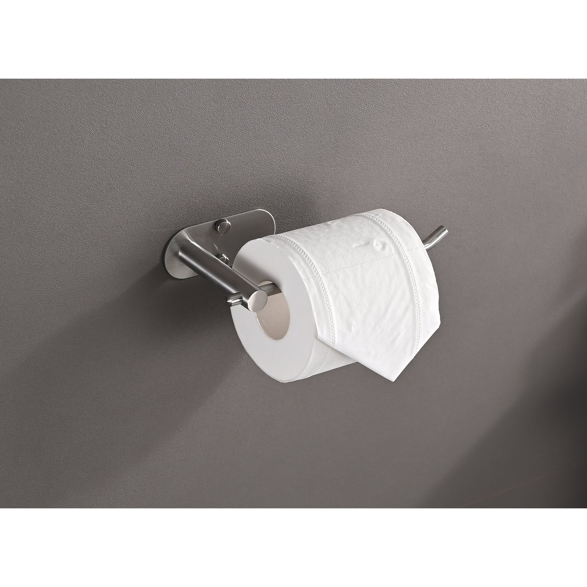 Sleek stainless steel toilet paper holder mounted on a textured gray wall with a white roll installed