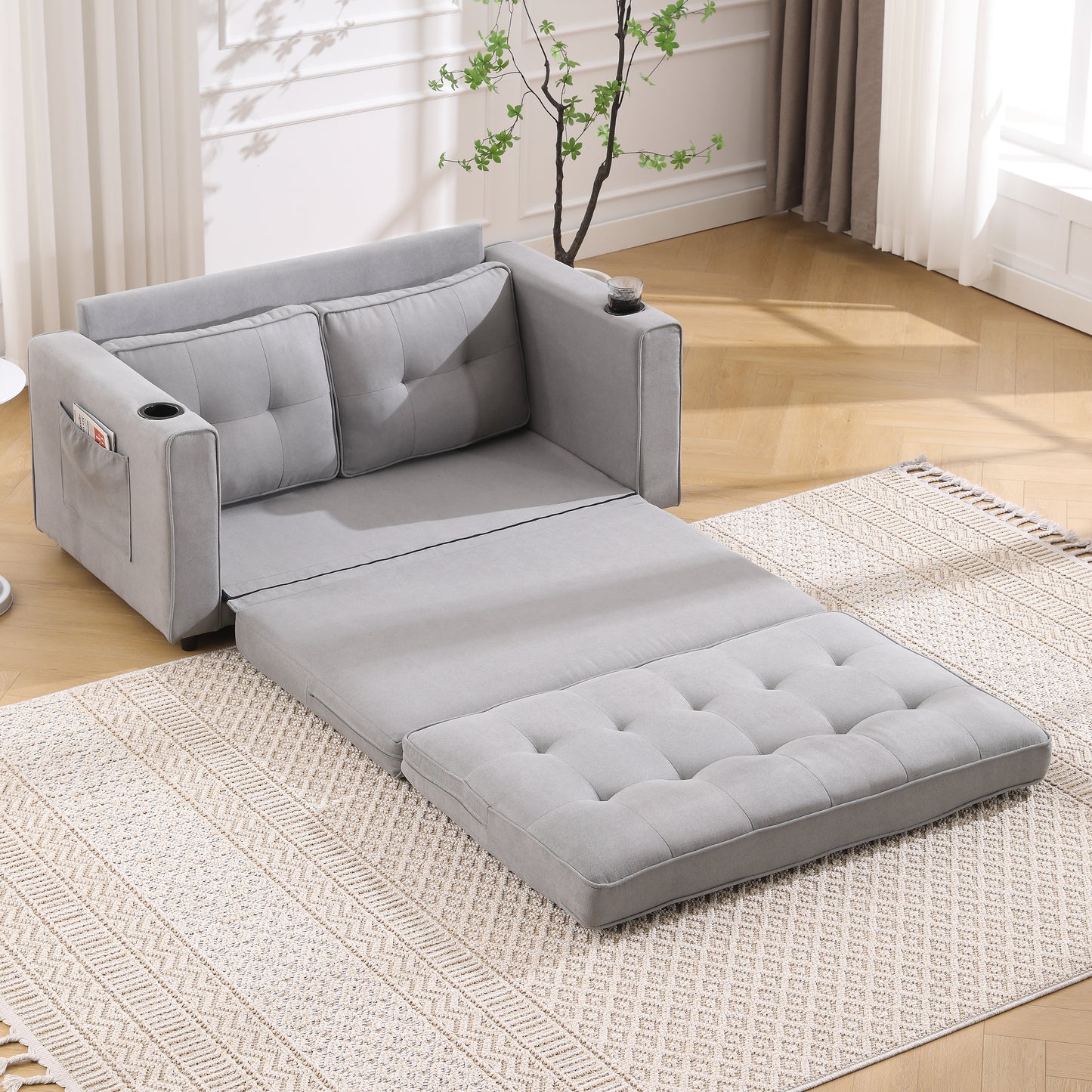 Gray convertible sofa bed extended into a chaise lounge on a patterned rug
