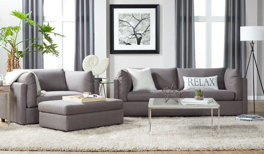 Plush grey sectional sofa with matching ottoman and throw blanket