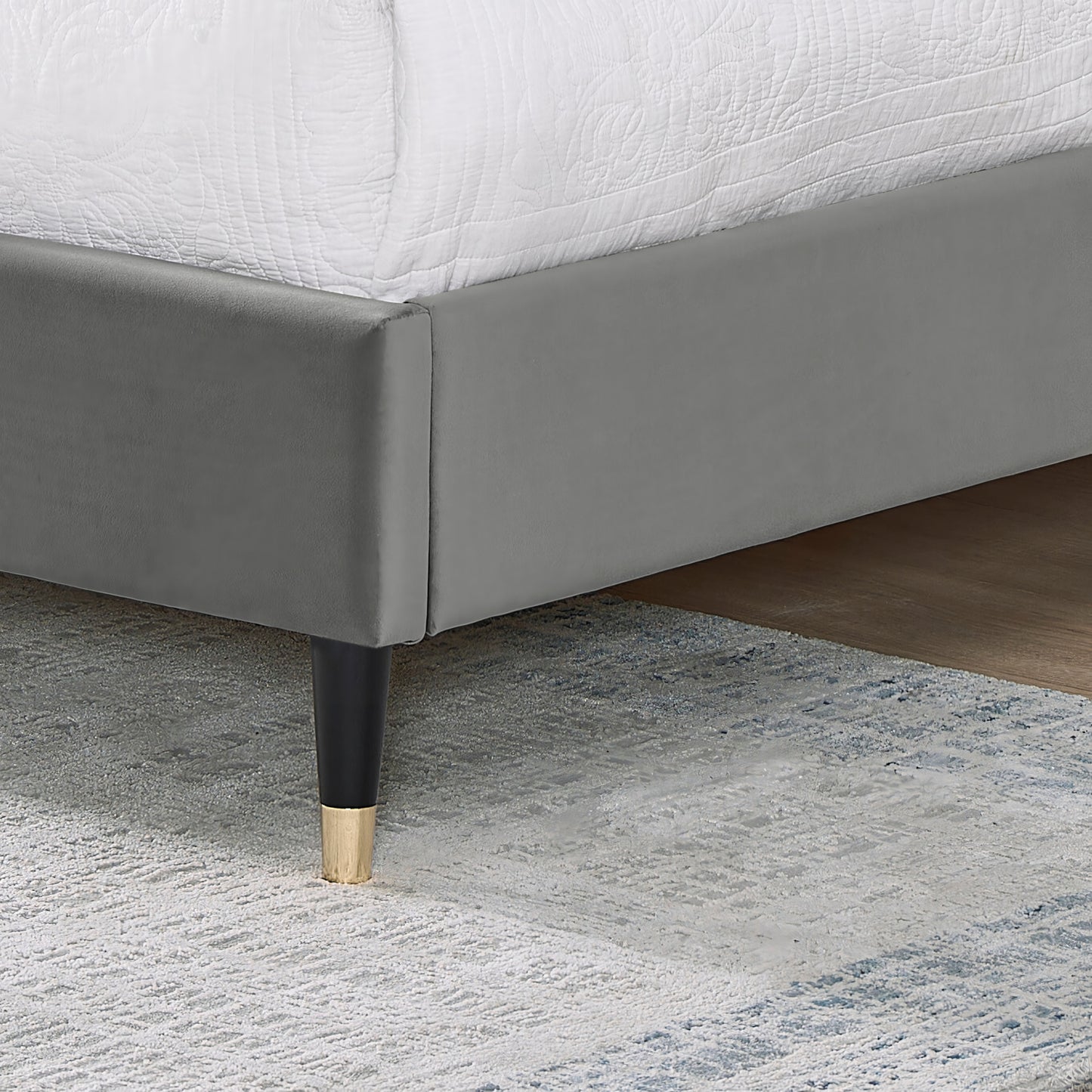 Grey velvet upholstered bed frame with black and gold tapered legs modern style