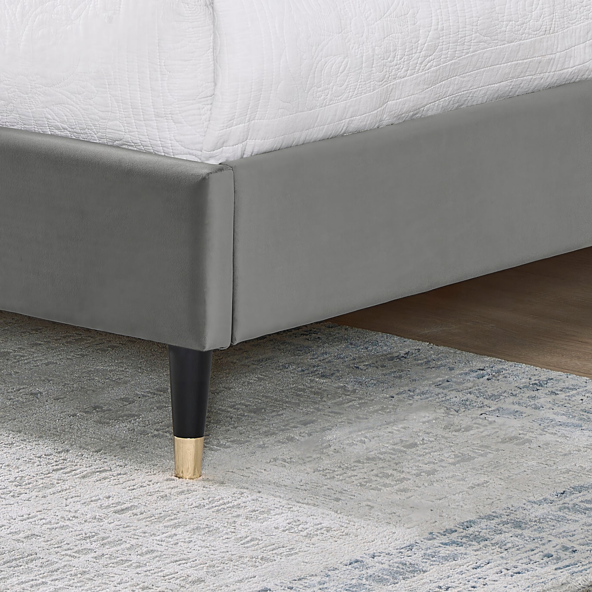 Grey velvet upholstered bed frame with black and gold tapered legs modern style