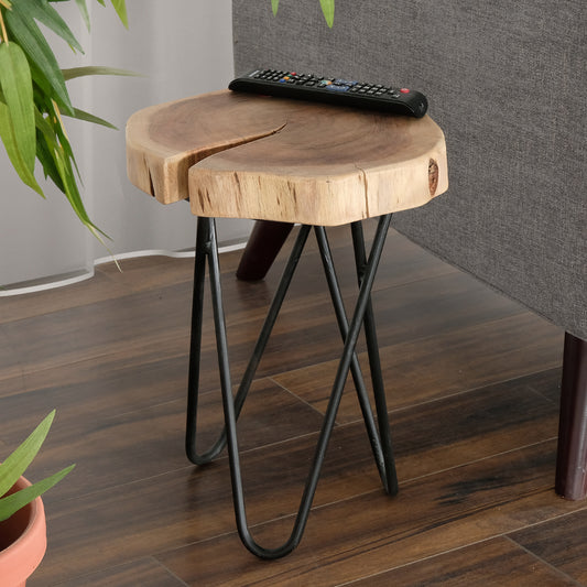 Natural wood slice side table with black hairpin legs and remote on top