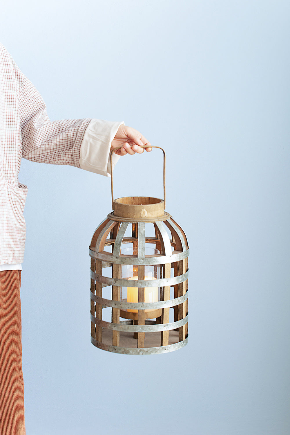 Rustic wood and metal lantern with a lit candle ideal for outdoor decor
